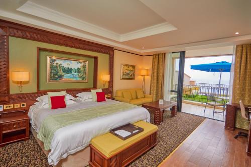 a hotel room with a large bed and a balcony at Goma Serena Hotel in Goma