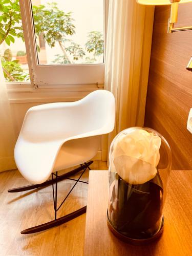 a white chair and a trash can in a room at Hotel Carbonell in Llança