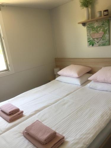 two twin beds in a room with towels on them at Mobile home "Sun" Jezera Village , otok Murter in Jezera