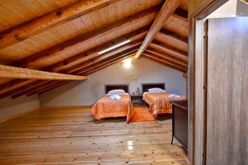 two beds in a room with wooden ceilings at Elizabeth Country House in Ágios Matthaíos