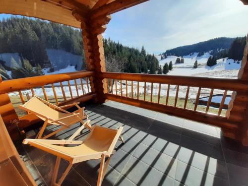 two chairs sitting on the porch of a cabin at къщи за гости Под звездите in Pamporovo