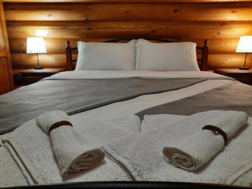 a bedroom with a bed with towels on it at къщи за гости Под звездите in Pamporovo