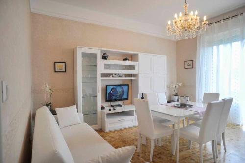 a dining room with a white table and white chairs at JUST LAKE in Bellagio