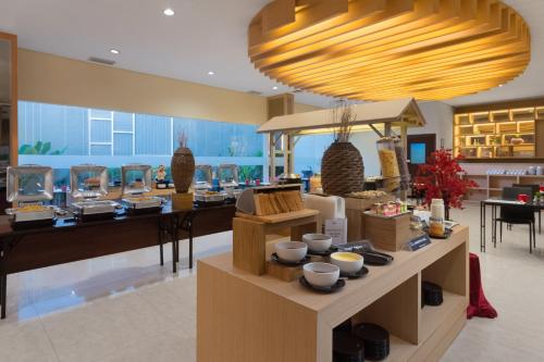 a store with a large chandelier above a table with bowls at Hotel NEO Cirebon by ASTON in Cirebon