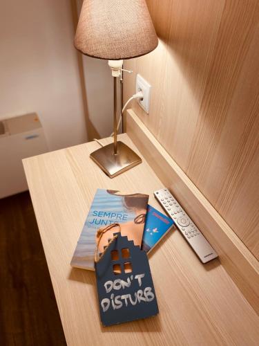 a book sitting on a table next to a remote control at Hotel Carbonell in Llança