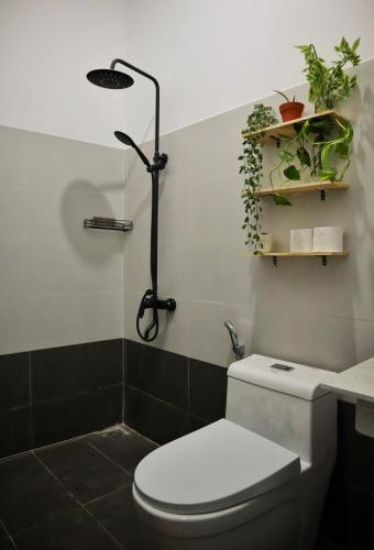 a bathroom with a toilet and a shower with plants at Cube homestay Phan Rang cách biển 300m to the beach in Phan Rang