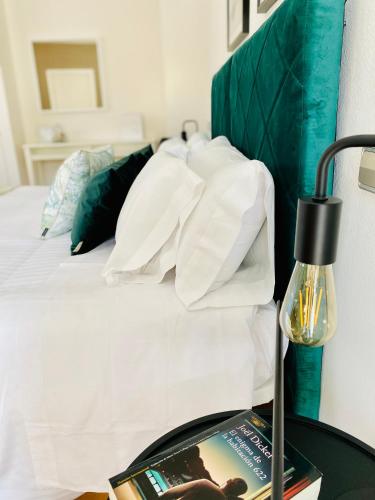 a bed with white pillows and a book and a lamp at Hotel Carbonell in Llança