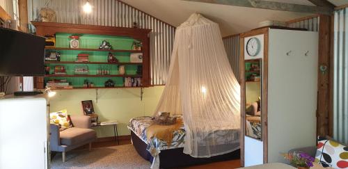 a bedroom with a bed with a net in it at Fig Tree Retro Studio in Cudgera Creek