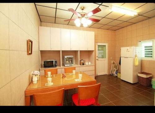 a kitchen with a table and chairs and a refrigerator at 儷池2房2-5人包棟 in Chishang