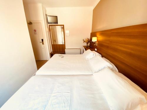 two twin beds in a room with a wooden headboard at Hotel Carbonell in Llança