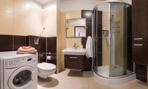 a bathroom with a washing machine and a sink at Zygmunta Slominskiego 5 - P&O Apartments in Warsaw