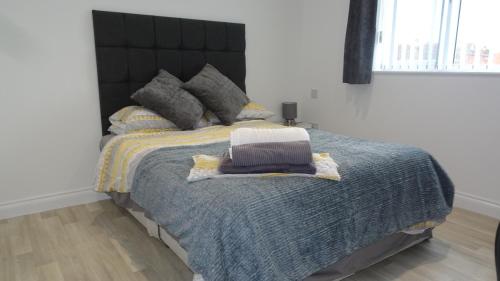 a bedroom with a large bed with a black headboard at St Margaret's House in Leamington Spa