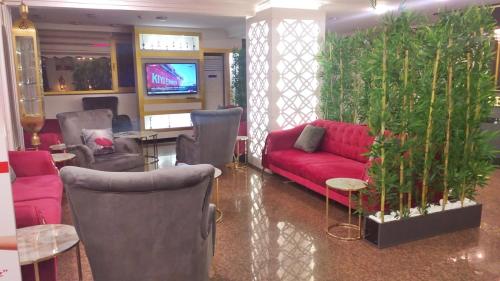 een woonkamer met een rode bank en stoelen bij Yilmazel Hotel in Gaziantep