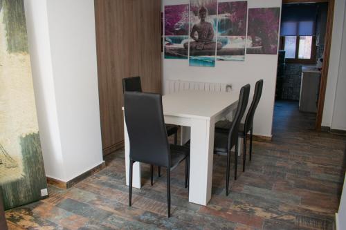a white table with black chairs in a room at Apartamentos Cerezo in La Codosera