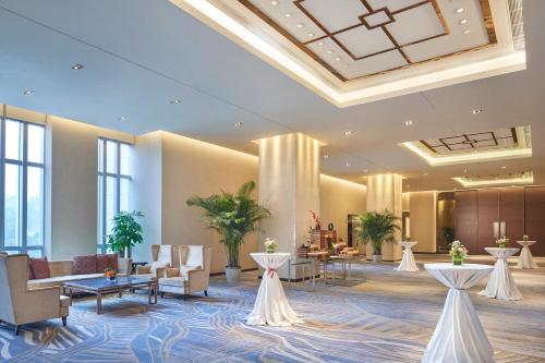 a lobby of a hotel with tables and chairs at Junluxe Hotel Guangzhou Science City-Free Shuttle Bus Service to Guangzhou Canton Fair in Guangzhou