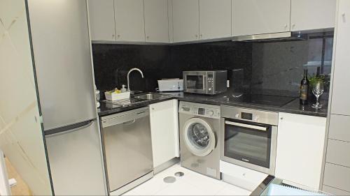 uma cozinha com uma máquina de lavar roupa e um micro-ondas em Valadim Flats no Porto