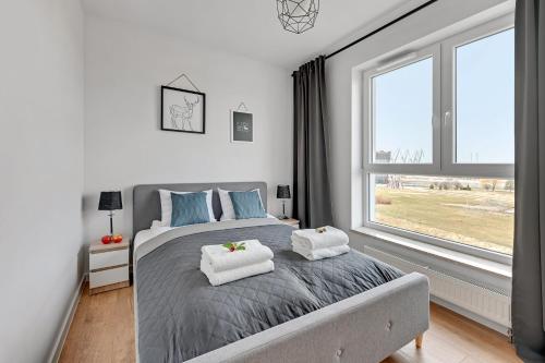 格但斯克的住宿－Apartament Bastion Sky Gdańsk TriApart，一间卧室配有带毛巾的床