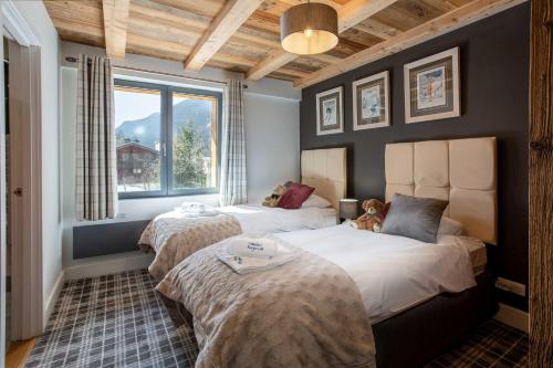une chambre avec deux lits et une fenêtre dans l'établissement Chalet des Amis appt 2 - Chamonix All Year, à Chamonix-Mont-Blanc