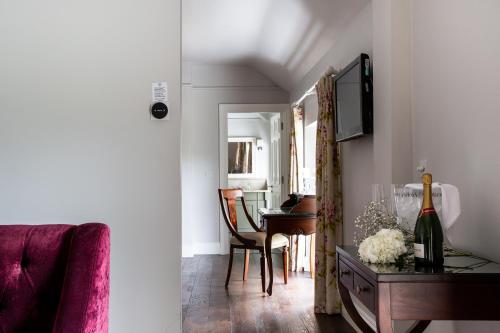 a living room with a table and a dining room at Millbrook Lodge in Ballynahinch