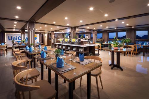 a restaurant with tables and chairs in a room at UniCharm Cruise in Ha Long