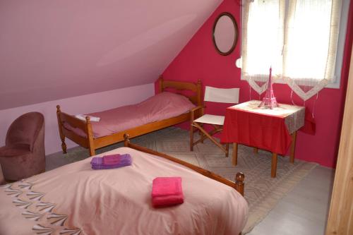 une petite chambre avec deux lits et une table dans l'établissement Les Talents Aiguilles, à Breuil-sur-Vesle