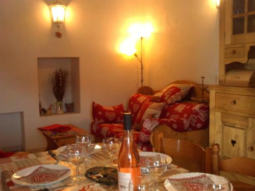 un salon avec une table avec une bouteille de vin dans l'établissement appartement gentiane 4personnes dans gite 