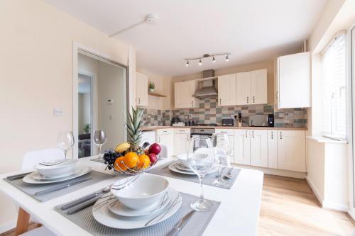 a kitchen with a table with a bowl of fruit on it at Jupiter House by TJ Serviced Property in Peterborough