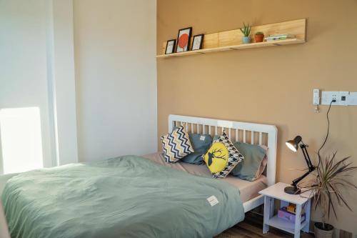 a bed with pillows on it in a bedroom at Cube homestay Phan Rang cách biển 300m to the beach in Phan Rang