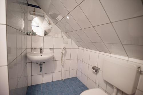 een witte badkamer met een wastafel en een toilet bij Angelis Pension in Kelsterbach