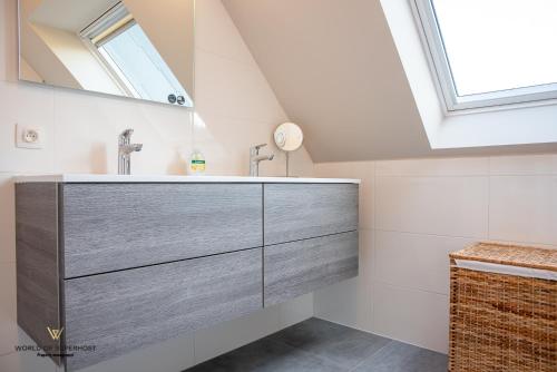 a bathroom with a sink and a mirror at Spacious apartment in the heart of Ostend near the sea in Ostend
