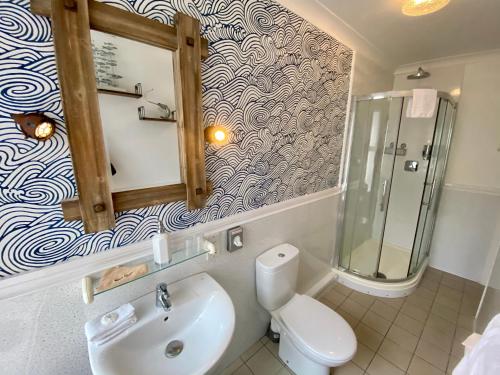 a bathroom with a toilet and a sink and a shower at Sunny Bank Guest House in Tenby