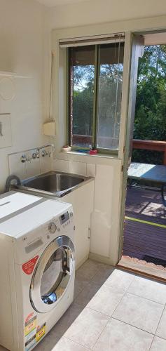 a kitchen with a washing machine and a sink at City Edge Lower Plenty in Lower Plenty