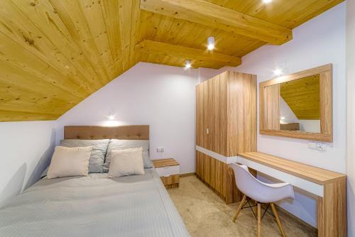 sypialnia z łóżkiem, biurkiem i krzesłem w obiekcie APARTAMENTY NA SKARPIE w mieście Szczawnica