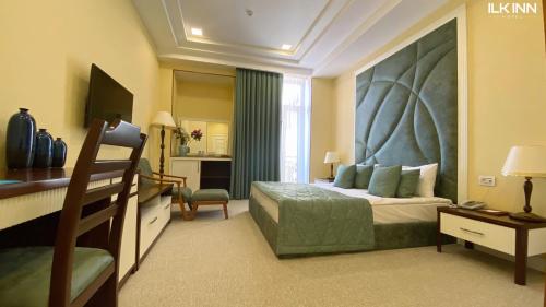 sypialnia z łóżkiem z dużym zagłówkiem w obiekcie ILK INN HOTEL w mieście Qusar