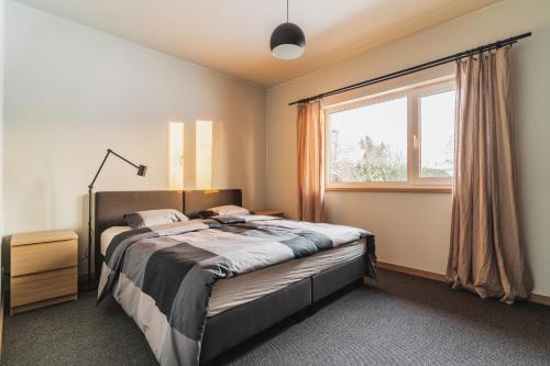 ein Schlafzimmer mit einem großen Bett und einem Fenster in der Unterkunft Prieka Villa in Sigulda