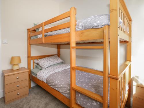 sypialnia z 2 łóżkami piętrowymi i szafką nocną w obiekcie The Croft Bungalow w mieście Wigton