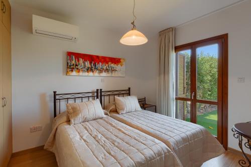 a bedroom with a bed and a large window at Aphrodite Hills Rentals - Junior Villas in Kouklia