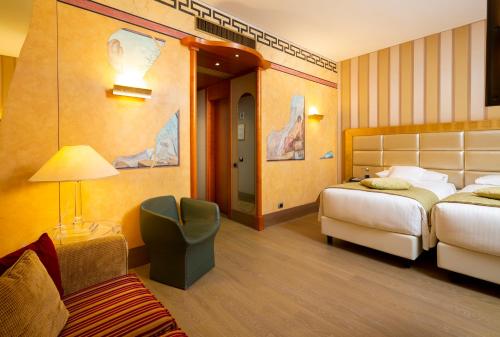 Pokój hotelowy z 2 łóżkami i krzesłem w obiekcie c-hotels Rubens w Mediolanie