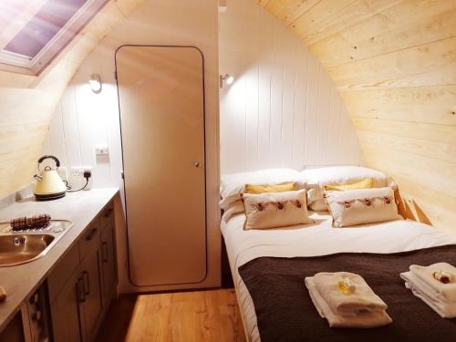 a small bedroom with a bed and a sink at The Honeybee Pod in Penrith