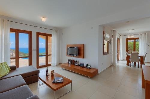 a living room with a couch and a table at Aphrodite Hills Rentals - Junior Villas in Kouklia