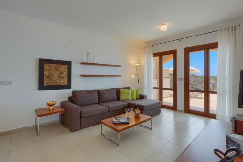 a living room with a couch and a table at Aphrodite Hills Rentals - Junior Villas in Kouklia