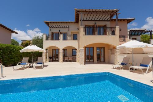 eine Villa mit einem Pool und einem Haus in der Unterkunft Aphrodite Hills Rentals - Junior Villas in Kouklia