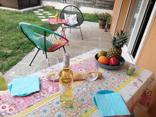 - une table avec une bouteille de vin et un bol de fruits dans l'établissement Lovely Studio & Garden - près des plages Cagnes-sur-Mer, à Cagnes-sur-Mer
