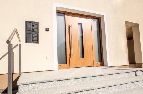 a wooden door of a house with stairs at Kopeindlgut Apartments in Wals