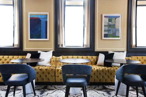 a restaurant with a couch and tables and chairs at Kimpton Cottonwood Hotel by IHG in Omaha