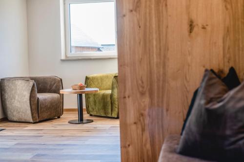 a room with a chair and a table and a window at Kopeindlgut Apartments in Wals