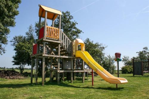 a playground with a slide in a park at Wikkelhuis 12 in Stavoren