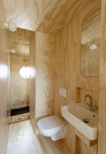 a bathroom with a white toilet and a sink at Wikkelhuis 12 in Stavoren