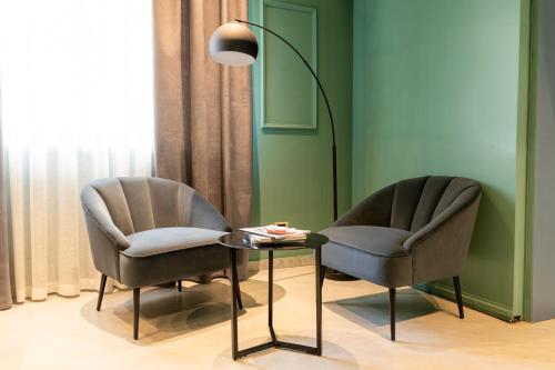 due sedie e un tavolo e una lampada in una stanza di Hotel Enzo a Porto Recanati