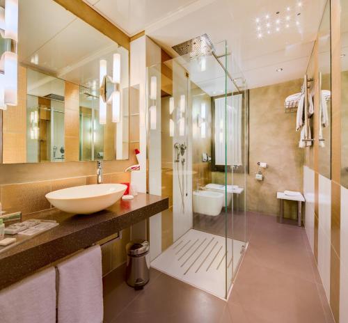 a bathroom with a sink and a glass shower at c-hotels Rubens in Milan